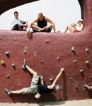 Mann hängt an Boulderwand