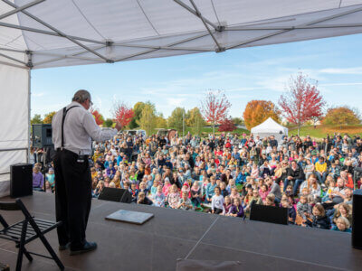 Ein Schauspieler steht vor Publikum auf einer Bühne
