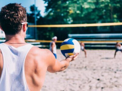 Mann beim Aufschlag Beachvolleyball