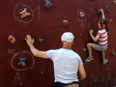 Mädchen klettert an Boulder wand hoch