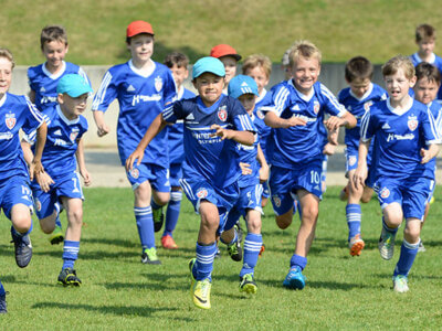 Fußballspielende Kinder rennen