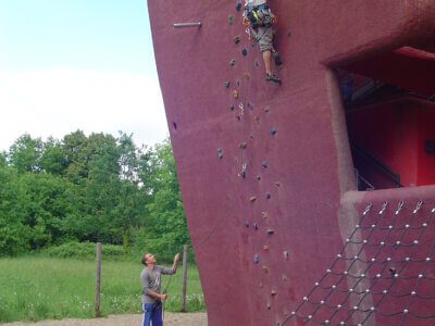 Männer klettern an Boulderwand hoch